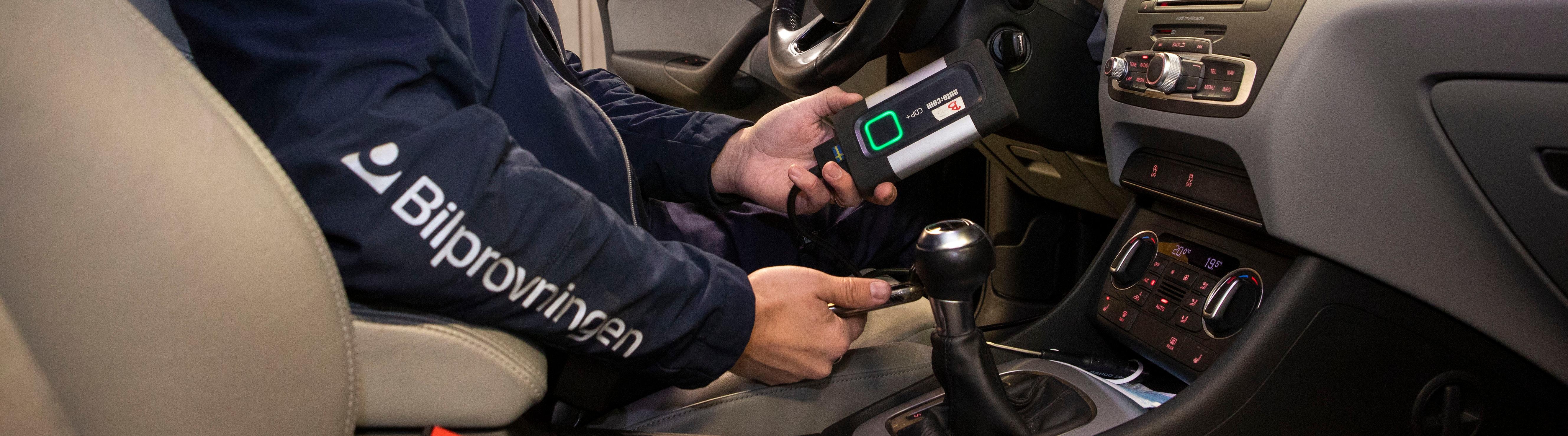 Besiktningstekniker kontrollerar elektroniken i en bil