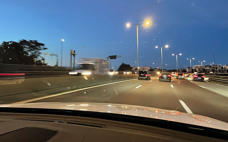 Bild tagen från framsätet på en bil på motorväg i mörker med bländande trafik